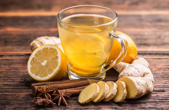 Cup of ginger tea with lemon on wooden table